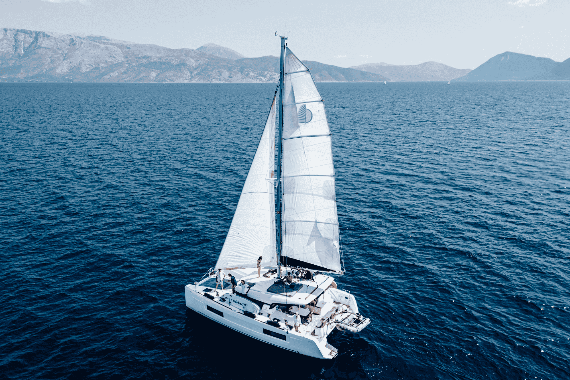 O familie se pregătește să urce pe un yacht ancorat într-un port la Marea Mediterană.