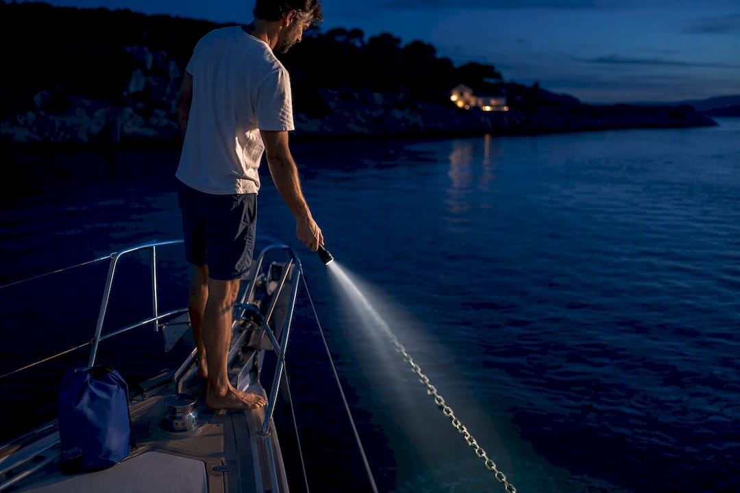 Sailor checking anchor rode after dark