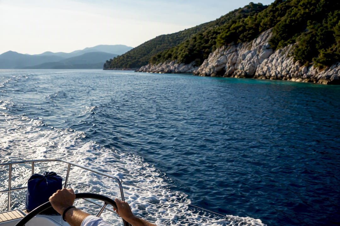 Family sailing past Sporades island coastline