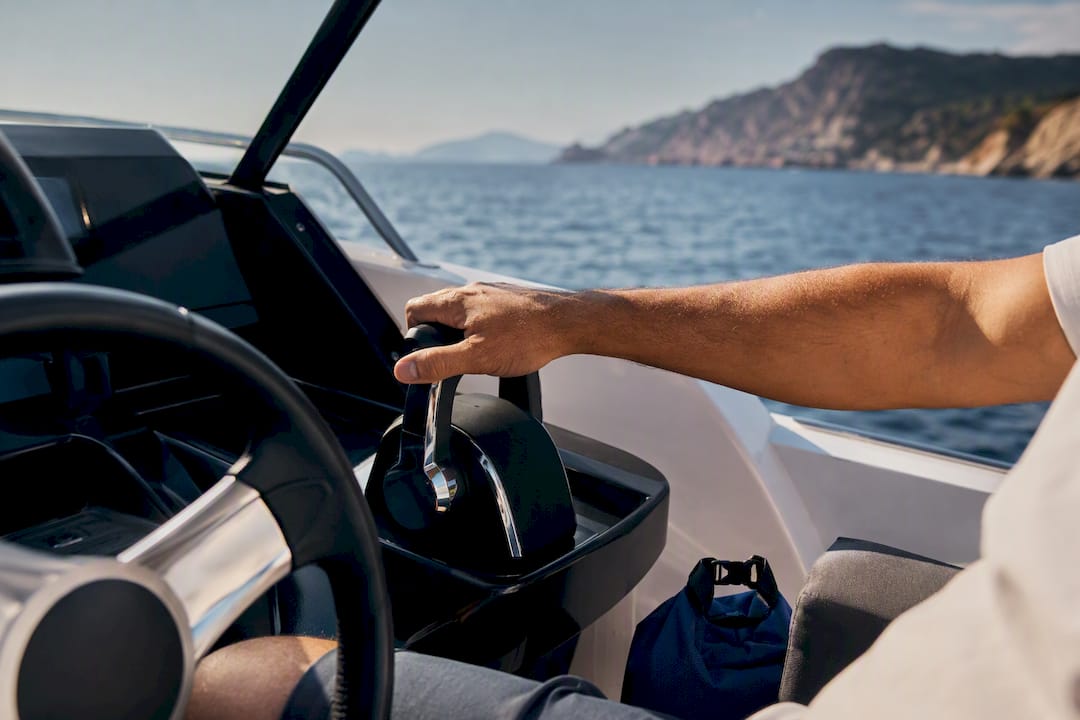 Anonymous boat helm overlooking Greek coastline