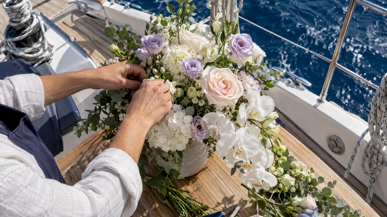 Florist arranging proposal flowers on yacht deck