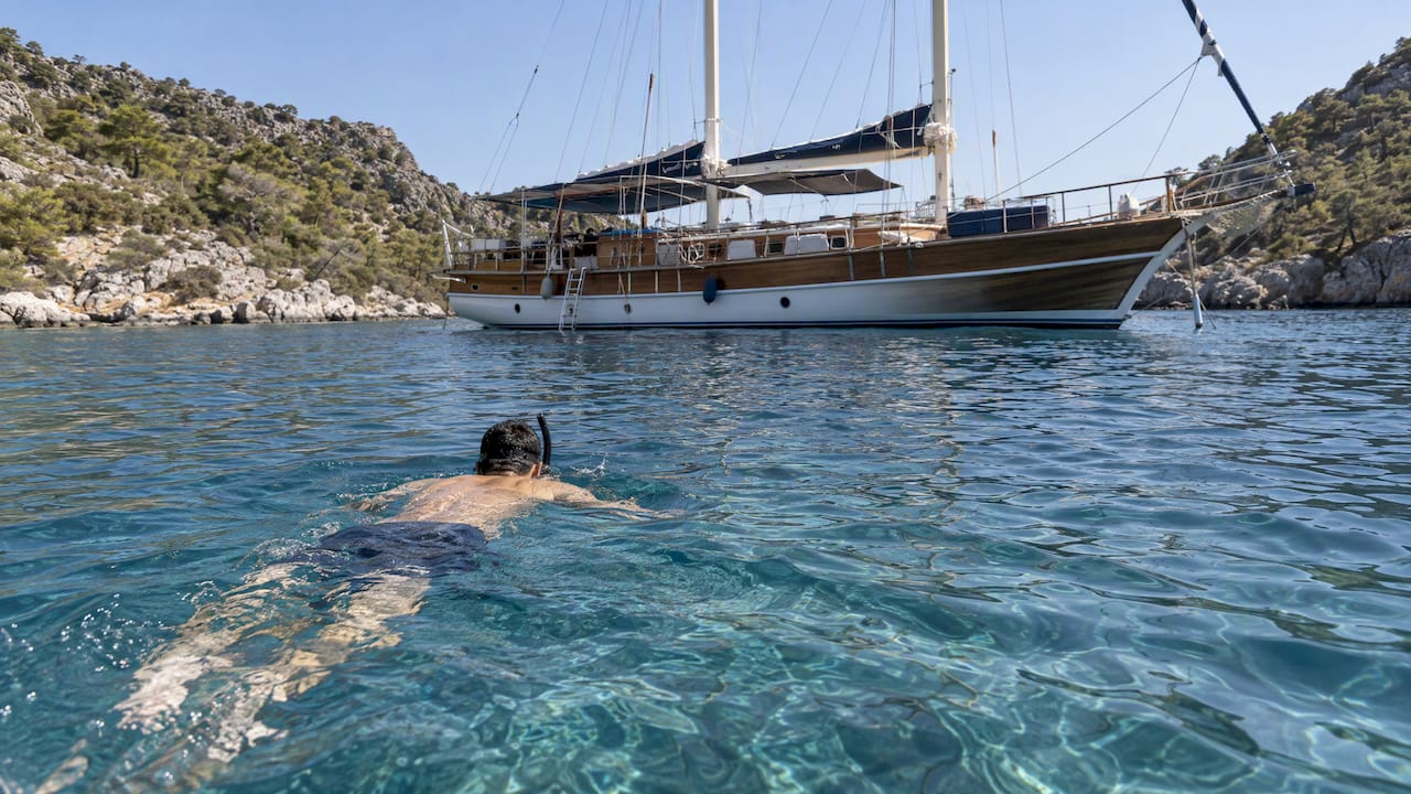 Snorkeler swimming beside an anchored gulet